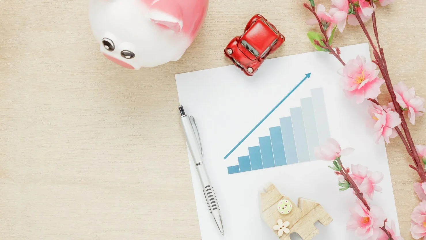Top View Business Office Desk Concept Saving Money With Charted Summary Wood House Also Car Clock Wooden Shelf Beautiful Pink Flower With Pen Wood Background With Copy Space 1921 38